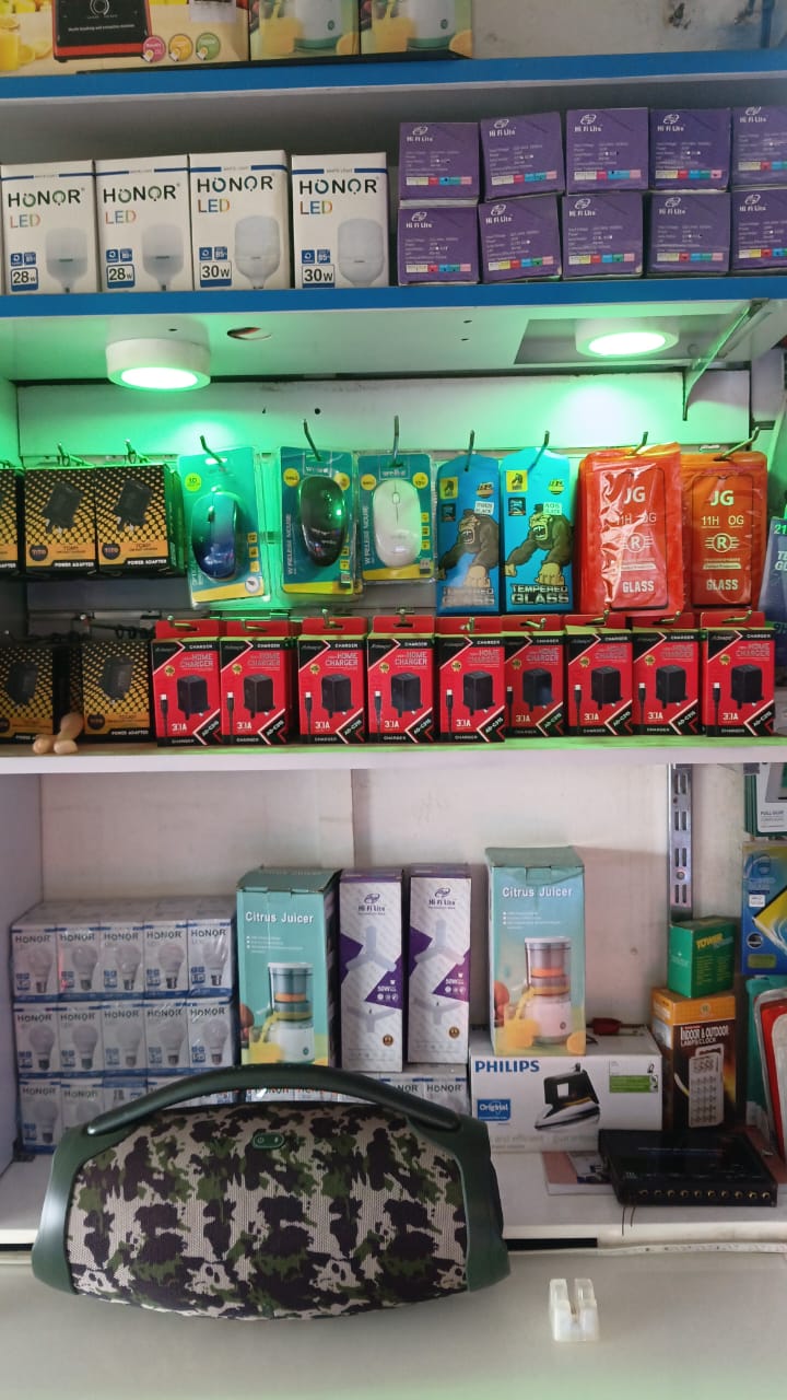 Steady Company (U) Ltd product shelves — phones, LED bulbs, chargers, speakers, Bwamba Road, Fort Portal